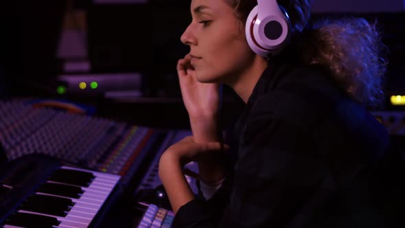 Female sound engineer working at a mixing desk alt