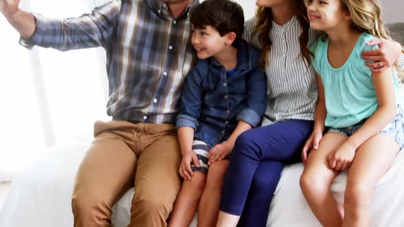 Happy family taking a selfie on mobile phone alt