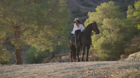 Wide Shot of Happy Equestrian and Graceful Purebred Horse Looking to Different Directions alt