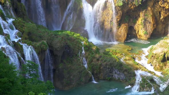 Aerial slow motion view of Plitvice river falls and foot bridge alt