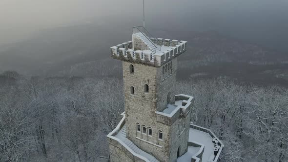 Observation Tower on Mount Akhun Covered in Winter During Snowfall alt