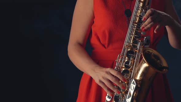 Beautiful Woman in Red Concert Dress Playing a Melody on Saxophone