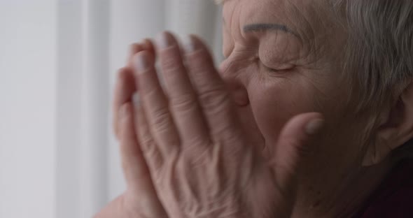 Old woman crying covering her face with her hands. Depression and despair in an older female. alt