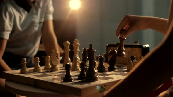 Cute young girl makes a responsible move with a chess piece during a competition