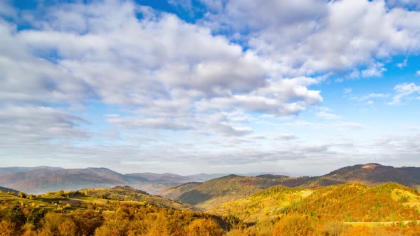 Lush Autumn Trees Cover Slopes in Highland Under Cloudy Sky alt