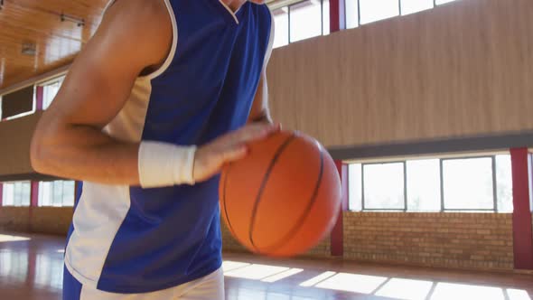 Caucasian male basketball player practicing dribbling and shooting with ball alt