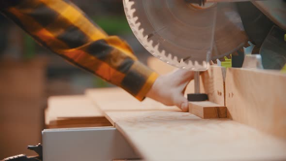 Carpentry - a Woodworker Cutting the Wooden Detail with a Sharp Circular Saw - Cutting Out a Little alt