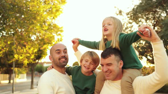 Gay Male Couple with Children Having Fun with Kite Toy Outdoor at City Park Lgbt Family and Love alt