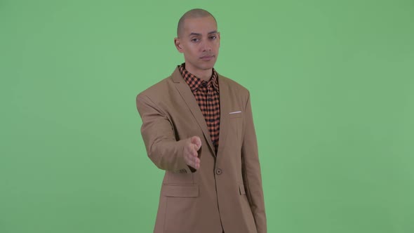 Tired Bald Multi Ethnic Businessman Giving Handshake alt