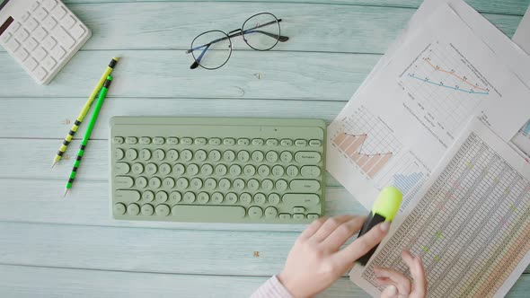 A Worker is Typing on Computer Keyboard and Analyzing Business Documents alt