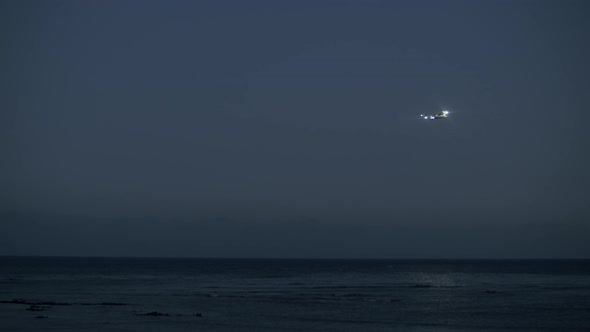 Plane Coming in for a Landing Over the Ocean, Evening View