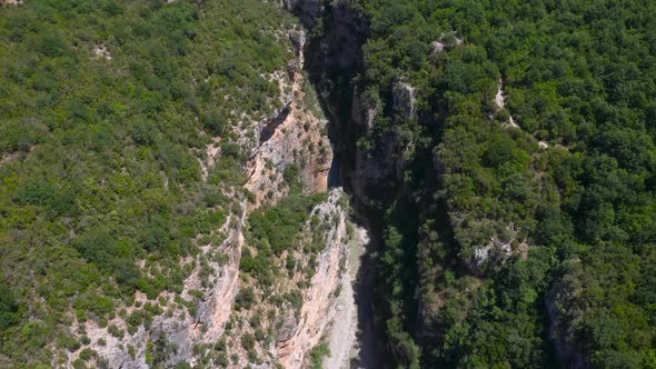 Birds eye view of deep gorge between steep and huge green mountains of Benje Canyon. Aerial view. alt