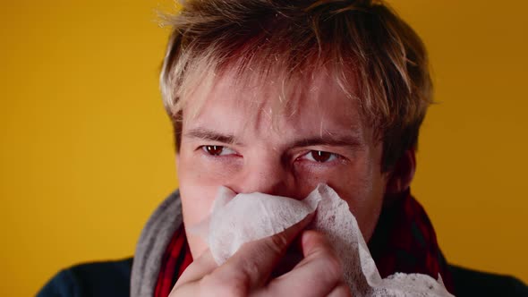 The man has a runny nose. A young guy in a scarf wipes his snot. alt