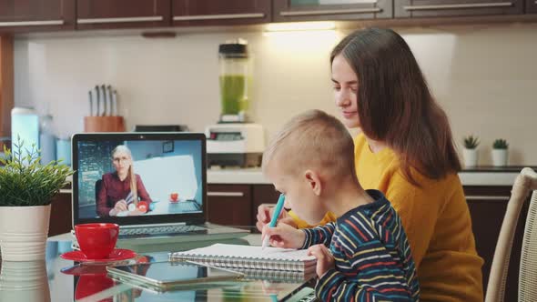 Mother Being Present at Son's Online Lesson with Teacher By Video Call on Computer