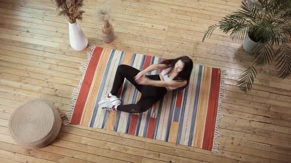 Top View of a Young Woman Exercising on a Wooden Floor