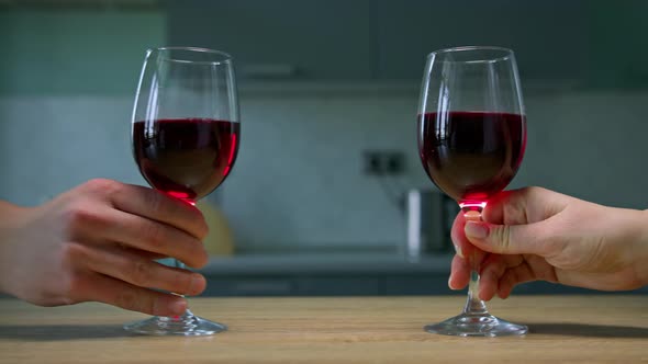 Female and male hands taking glasses with red wine. Close up