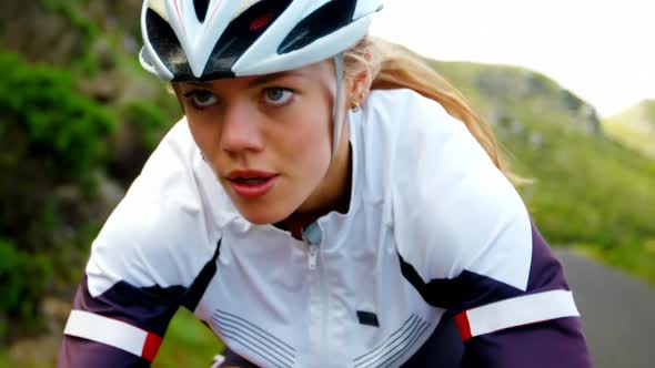 Female cyclist cycling on a countryside road alt