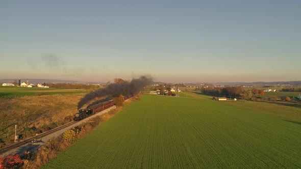 Aerial View of a Horse and Buggy Approaching a Rail Road Crossing in the Middle of the Amish Countryside and a Sunny Day alt