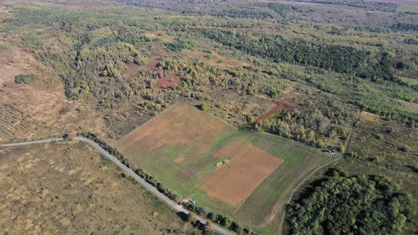 Drone Aerial View of Autumn Fields with Countryside Farmland Huts Around the Little Village alt