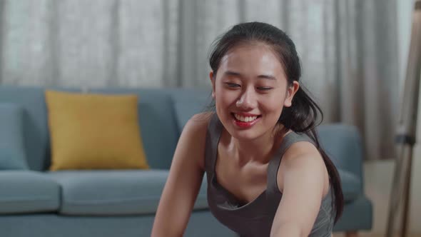 Young Asian Athletic Female In Sports Clothes Sitting On A Yoga Mat And Doing Hamstring Stretch alt
