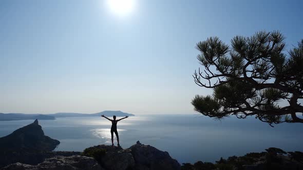 Shooting From Above From the Back of a Sporty Girl Standing on the Top of Mount Karaul-Oba in Crimea alt