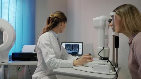 The Ophthalmologist Examines the Patient's Eye and Then Looks Into the Camera alt