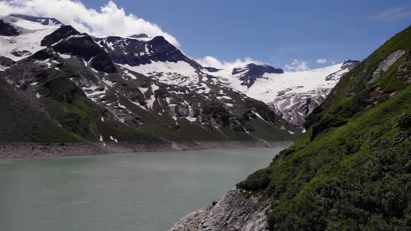 Peaceful Water Of Stausee Wasserfallboden Reservoir With Snow Mountains In Kaprun, Austria. - Aerial alt