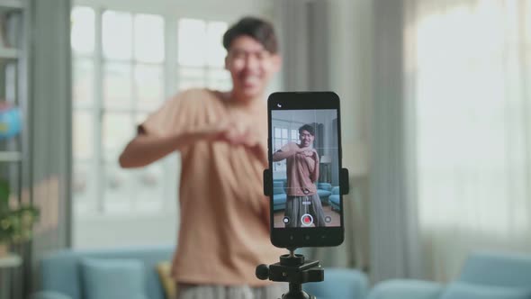 Display Smartphone Of Asian Man Dancing While Shooting Video Content For Social Networks alt