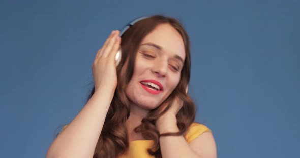 Young Girl in Yellow Shirt and Headphones Listening Music