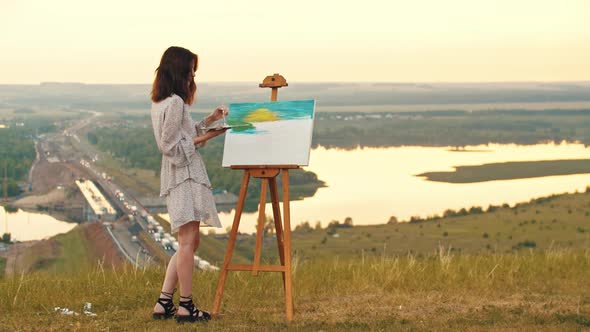 Young Woman Drawing a Painting on Sunset alt