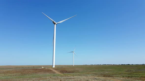 Working Wind Turbines Standing on the Field in Summer