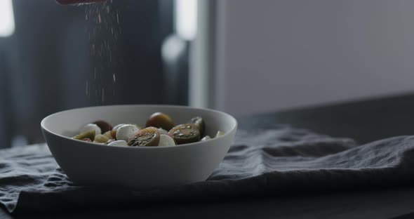 Slow Motion Put Seasoning Fettuccine in White Bowl on Linen Cloth alt