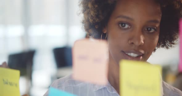Confident Afroamerican Businesswoman Attaching Stickers To Glass Wall and Brainstorming alt
