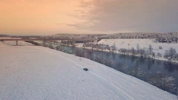 Drone shooting of a river against the background of a forest and a bridge alt