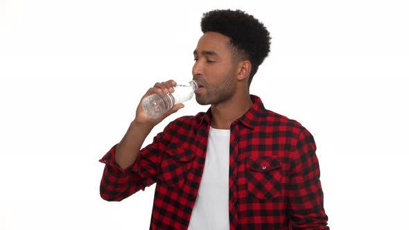 Halfturn Portrait of Handsome Darkskinned Guy in Red Plaid Shirt Being Thirsty Drinking Still Water alt