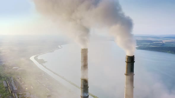 Aerial view of coal power plant high pipes with black smokestack polluting atmosphere. alt