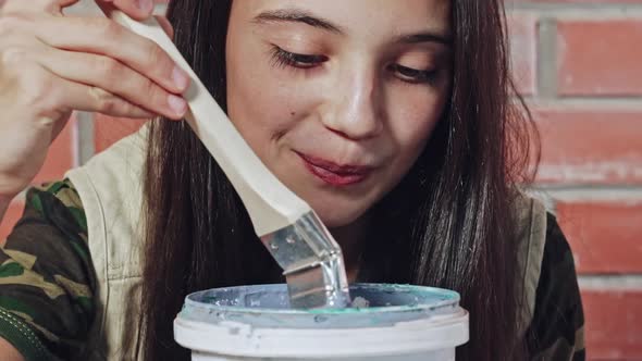 Close Up of Girl Playing with Bucket of Paint alt