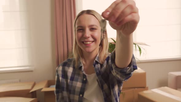 A Young Happy Woman Holds the Keys to a New Apartment or House in Her Hand