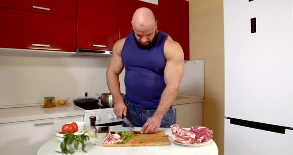 Man Is Chopping Green Onion and Herbs for Cooking at Home Kitchen, Preparing for Dinner alt