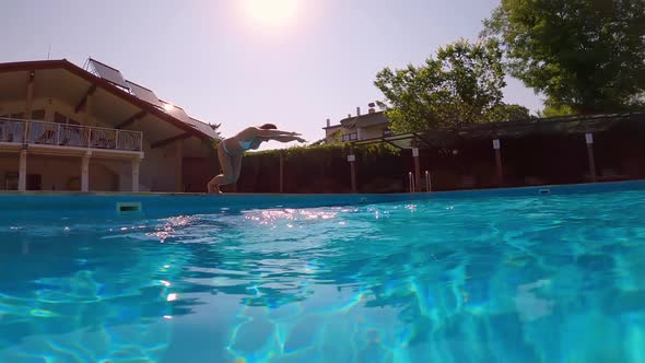 Underwater Shooting. Girl Dive in Blue Swimming Pool.