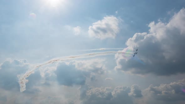 Group of four planes fulfills aerobatic figures in a cloudy sky with smoke