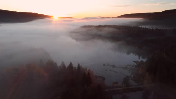 Aerial view of sunrise with fog above lake Schluchsee, Germany alt