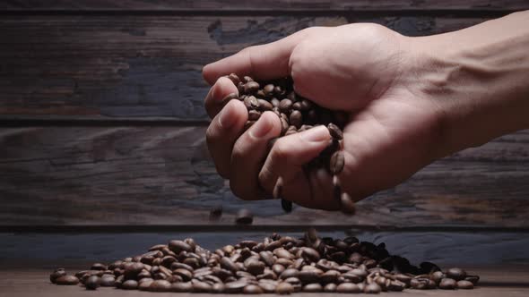 Human Hand touching Roasting brown Coffee Beans with steam. tracking shot, close up