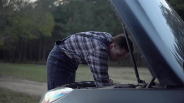 Auto Mechanic Fixing Broken Car Looking Under Open Hood