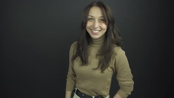 Excited Brunette in Brown Turtleneck Smiles and Shakes Hands alt