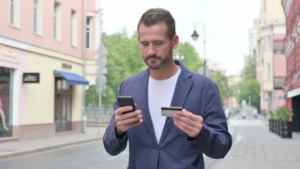 Man Having Online Payment Failure on Smart Phone While Walking Down the Street alt