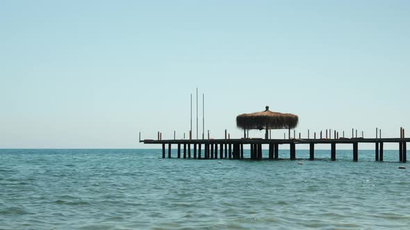 Wooden pontoon in sea, sun rays reflecting in clear sea water surface. alt