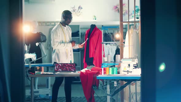 African Tailor is Comparing Colour of the Fabric to the Spectrum alt