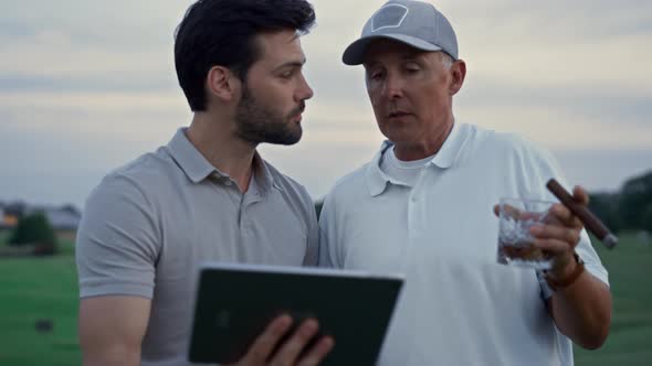 Two Golfers Browsing Tablet on Field Course alt
