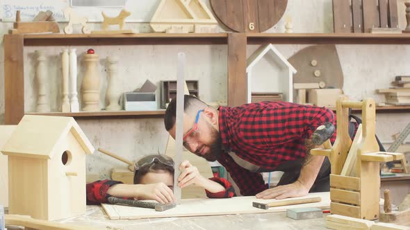 Father and Little Son Giving High Five While Visiting Woodworking Masterclass